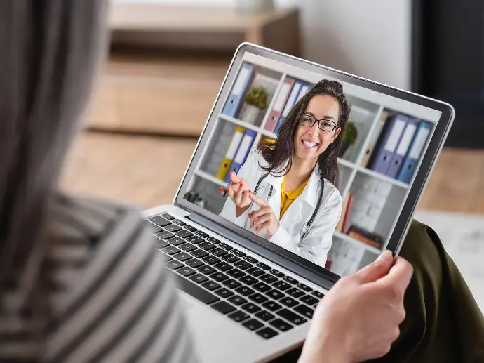 Remote Doctor on a latpop screen talking to an out  of view patient