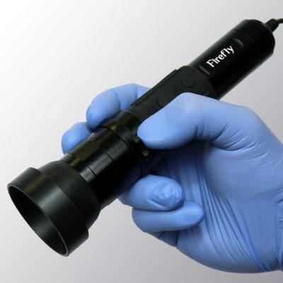 Blue gloved hand holding the DE605 General Examination Camera